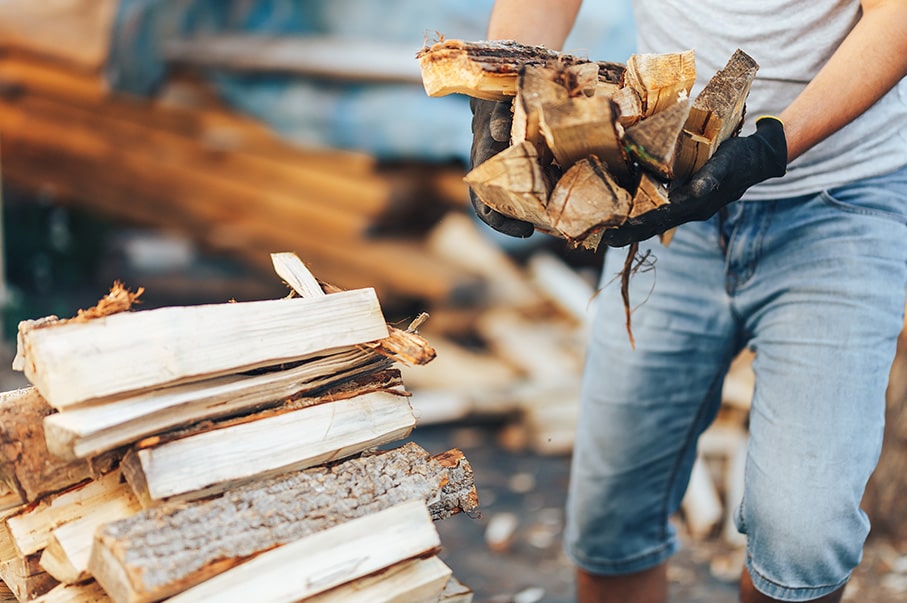 L'homme tient du bois de chauffage dans les mains